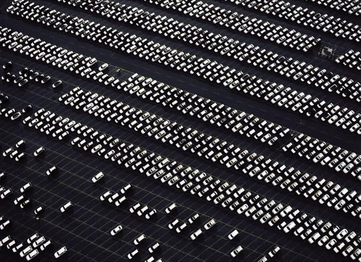 Aerial view of rows of parked vehicles in a large lot.