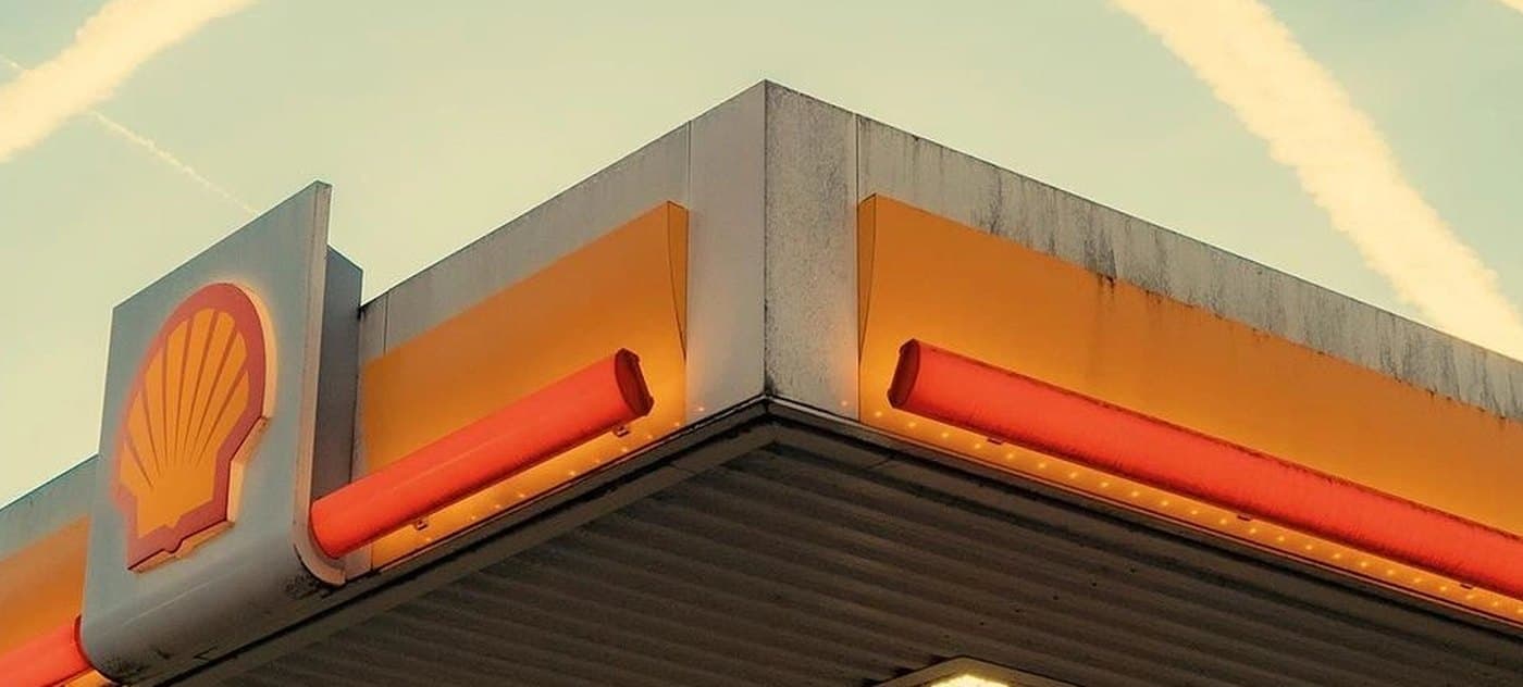 The orange canopy of a fuel station seen from below.