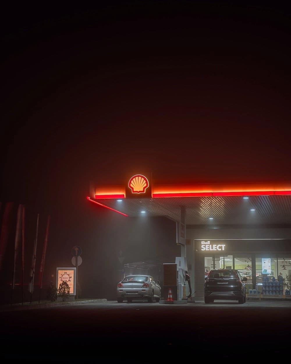 A fuel station forecourt at night.